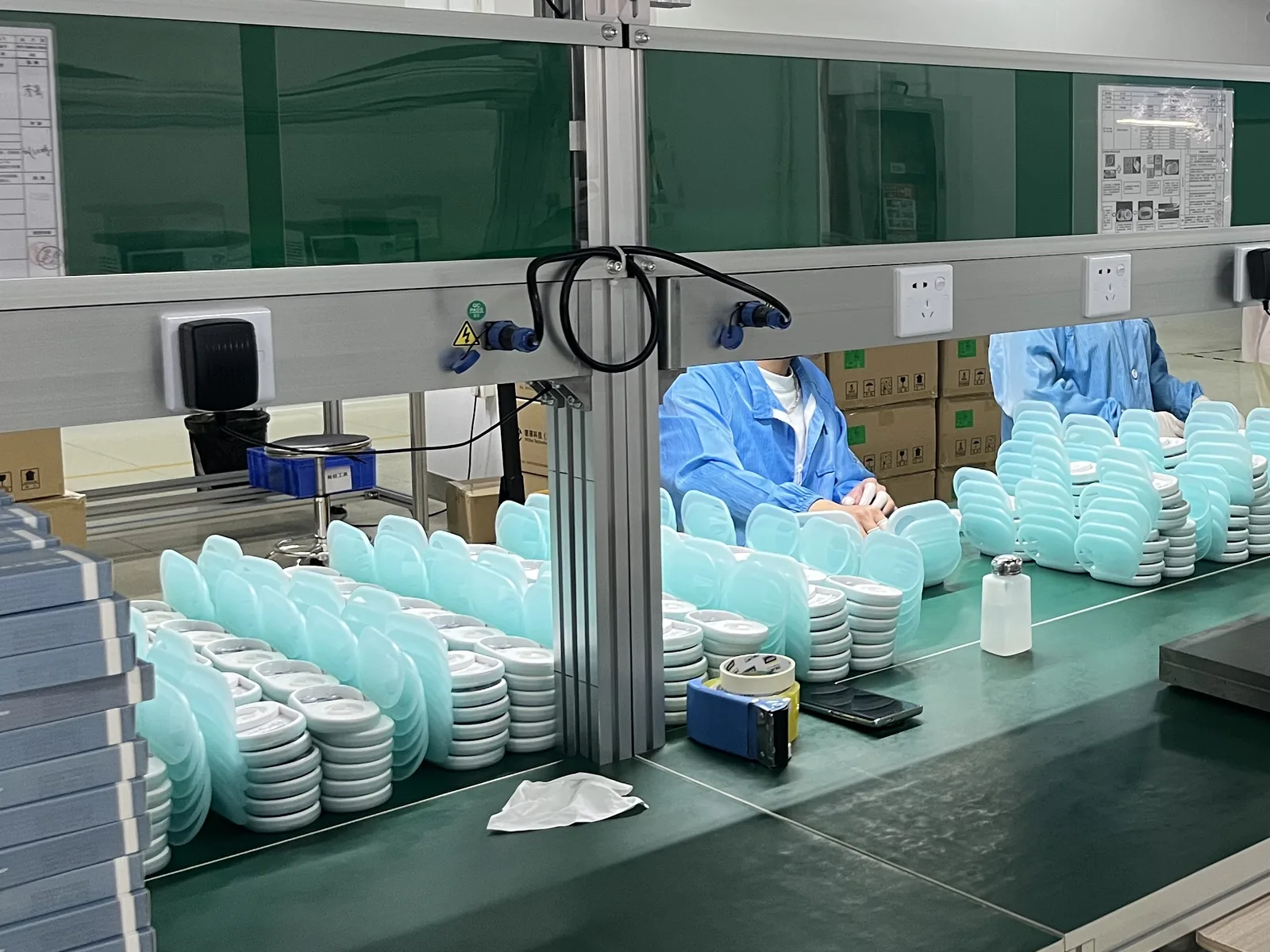 P20 sensor housings and mint-green storage cases stacked on the assembly bench at the Longgang production centre