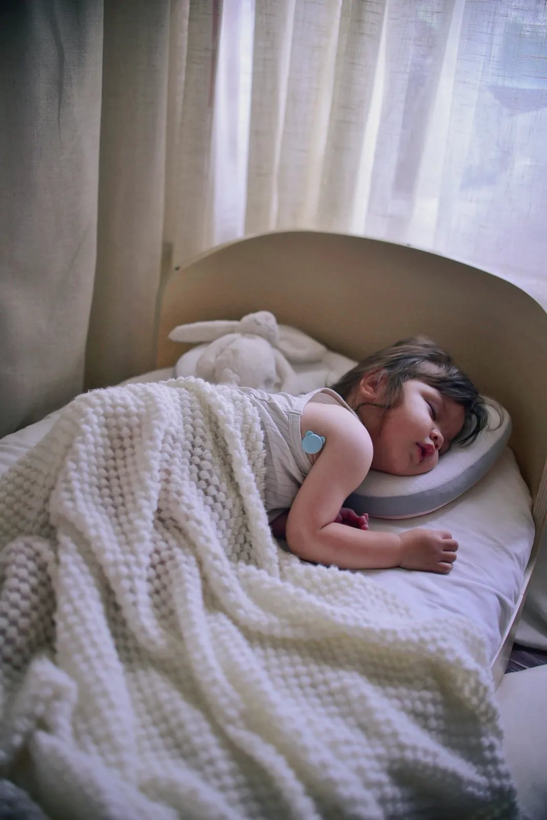 Baby sleeping undisturbed while wearing the P20 continuous fever monitor