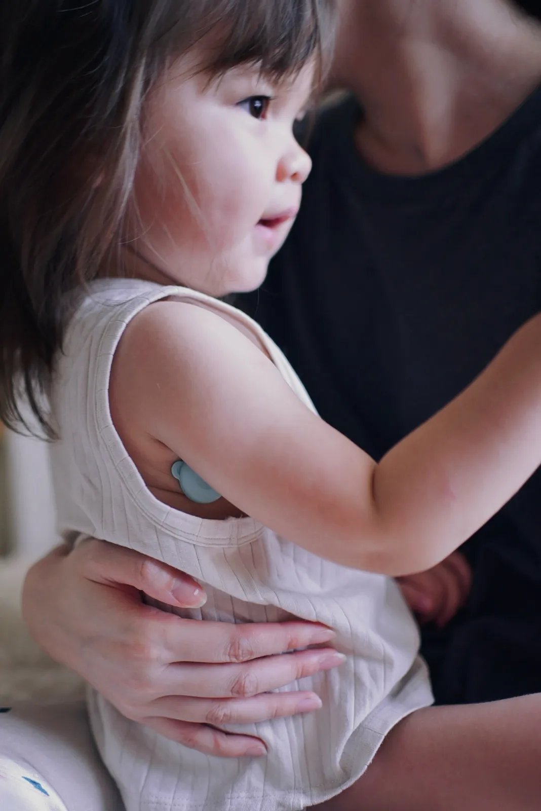 Toddler in a parent's arms wearing the 2g P20 sensor with a hypoallergenic patch